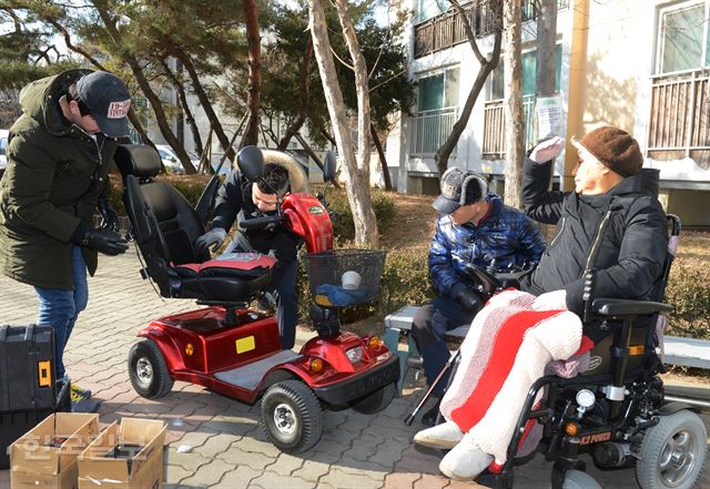 서울 강남구 한 임대아파트 앞에서 배재인(오른쪽부터) 마문숙씨가 강남구청이 파견한 기술자에게서 전동휠체어 수리를 받고 있다. 거동이 불편해 전동휠체어를 사용하는 장애인을 위한 수리서비스는 강남구의 대표적인 돌봄사업이다. 신상순 선임기자 ssshin@hankookilbo.com