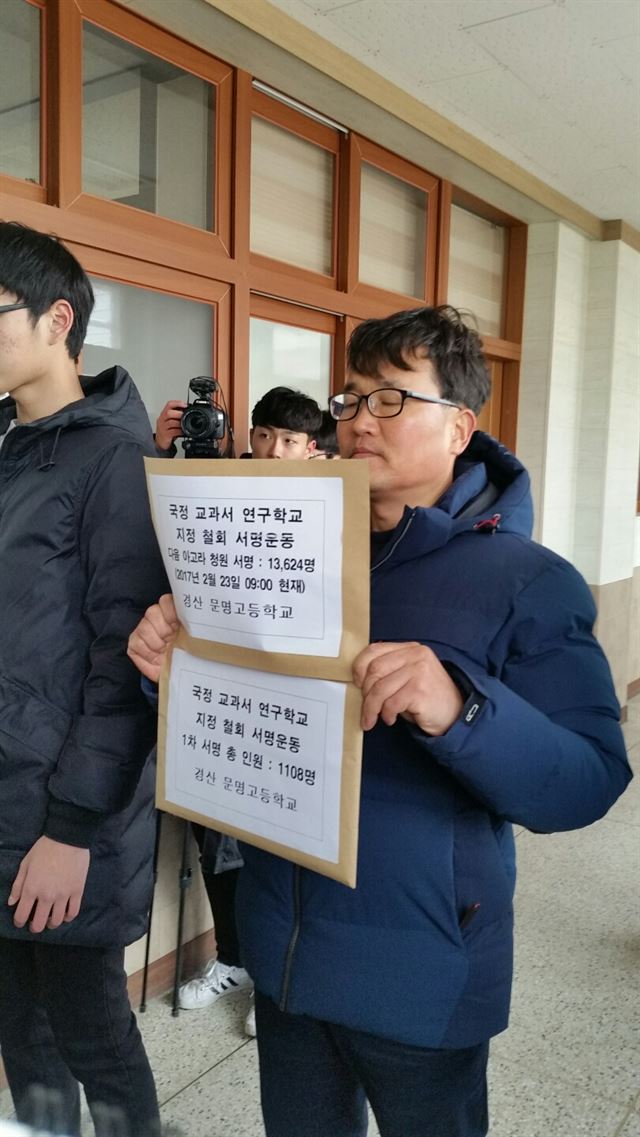 경북 경산 문명고의 학부모인 신상국 '문명고 국정교과서 지정 철회를 위한 대책위원회' 공동대표가 23일 철회 서명부를 김태동 교장에게 전달하기 위해 교장실로 향하고 있다. 뉴스1