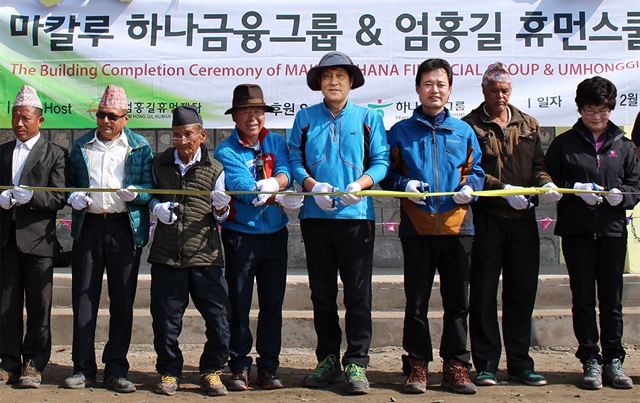 산악인 엄홍길(왼쪽에서 네번째부터) 대장과 김정태 하나금융지주 회장 등이 지난 23일 해발 1,900m에 위치한 네팔 마칼루에서 휴먼스쿨 준공식을 갖고 있다. 하나금융지주 제공