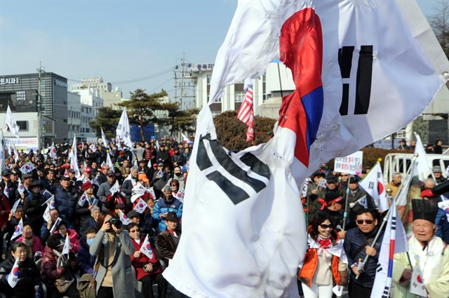 26일 오후 충북 청주시 상당공원에서 열린 박근혜 대통령 탄핵 기각을 촉구하는 태극기 집회에서 20대로 남성이 태극기를 불태웠다. 경찰은 이 남성을 붙잡아 조사를 하고 있다. 뉴스1