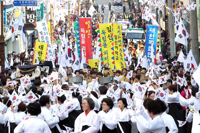 3·1절을 하루 앞둔 28일 부산 동구청 앞 도로에서 시민들이 태극기를 들고 일신여학교 만세운동 재현행사를 하고 있다. 연합뉴스