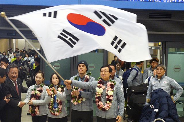 27일 인천공항을 통해 귀국한 2017 삿포로 동계아시안게임 선수단이 공항 입국장에서 대형태극기를 휘날리고 있다. 사진 왼쪽부터 이기흥 대한체육회 회장, 여자 피겨 최다빈, 여자 크로스컨트리 이채원, 남자 크로스컨트리 김마그너스, 김상항 한국선수단장. 영종도=뉴스1