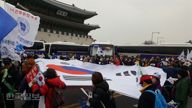 1일 '제15차 탄핵무효 애국집회' 참가자들이 서울 종로구 광화문 앞에서 대형 태극기를 들고 청와대 방면으로 행진하고 있다. 신은별 기자