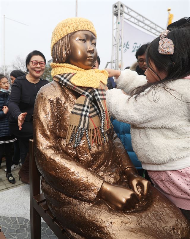 그림 11일 오후 경기 안양시 동안구 평촌중앙공원에서 열린 안양 평화의 소녀상 제막식에서 한 어린이가 소녀상에 모자와 목도리를 씌워주고 있다. 안양=연합뉴스