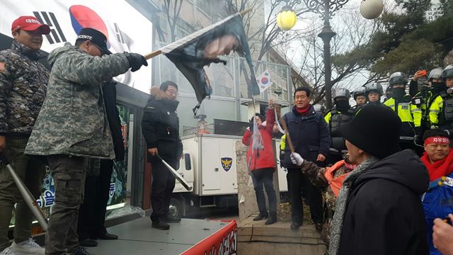 지난달 24일 박영수 특별검사 집 앞에서 열린 보수단체 집회에서 참가자들이 박 특검의 사진이 인쇄된 현수막을 불태우고 있다. 한국일보 자료사진.