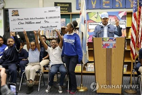 그래미상 시상식에서 최우수 신인상을 비롯해 3관왕을 차지한 래퍼 '챈스 더 래퍼'(오른쪽)가 6일 고향인 시카고의 웨스트코트 초등학교에서 시카고 공립학교 교육에 써달라며 100만 달러를 기부한다는 내용의 기자회견을 하고 있다. 시카고=AP 연합뉴스