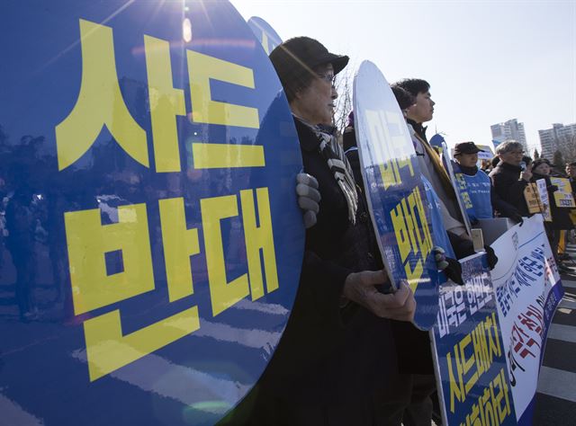 7일 오후 서울 용산구 국방부 앞에서 열린 ‘사드배치 규탄 기자회견’에서 참석자들이 관련 내용이 적힌 피켓을 들고 있다. 연합뉴스