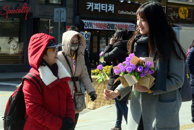 8일 오후 서울 종로구 광화문 일대에서 여성의 전화 회원들이 ‘세계여성의 날’을 맞이해 여성들에게 장미꽃을 선물하고 있다. 뉴시스