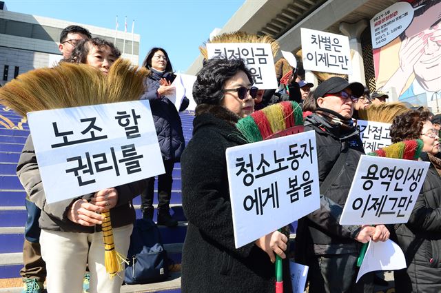 8일 오전 서울 종로구 세종문화회관 계단에서 열린 ‘제5회 청소노동자 행진 선포 기자회견’에서 참가자들이 빗자루와 손피켓을 들고 '청소노동자 노동조건 개선'을 요구하고 있다. 뉴시스