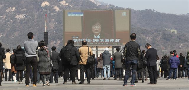 10일 오전 서울 광화문 광장에서 시민들이 헌법재판소의 박근혜 대통령 탄핵심판 선고 방송을 보고 있다. 연합뉴스