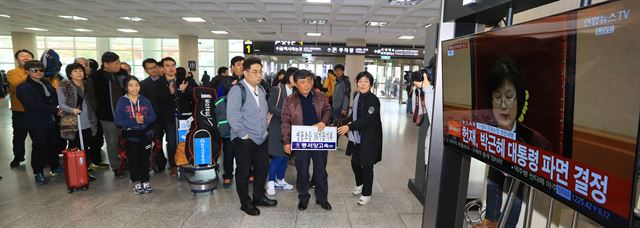 10일 오전 제주공항 도착층에서 제주도민들과 관광객들이 헌법재판소의 박근혜 대통령 탄핵심판 TV중계를 지켜보고 있다. 연합뉴스.