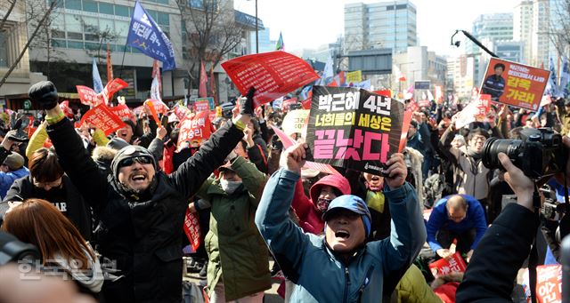 헌법재판소의 박근혜 대통령 탄핵인용이 발표된 10일 오전 서울 종로경찰서 앞에 모인 시민들이 방송을 보며 환호하고 있다. 서재훈 기자