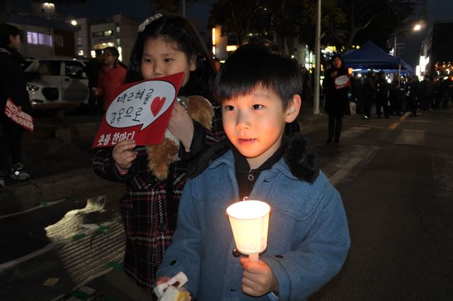 헌법재판소가 박근혜 전 대통령 탄핵을 결정한 10일 오후 제주시청 종합민원실 앞에서 진행된 촛불 승리 긴급집회에서 촛불을 든 어린이들이 환한 표정을 짓고 있다. 김영헌 기자.