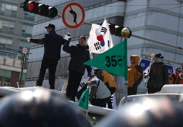 박근혜 전 대통령의 탄핵이 결정된 10일 오후 서울 종로구 안국역 사거리에서 탄핵을 반대하며 시위를 벌이는 시민들이 경찰 버스 위로 올라가 구호를 외치고 있다. 연합뉴스