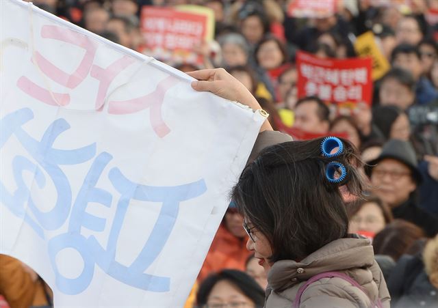 11일 오후 서울 광화문광장에서 열린 촛불집회'에서 한 참가자가 이정미 헌재 소장 대행의 헤어롤를 모방한 머리를 하고 참석해 사람들의 눈길을 끌었다. 왕태석기자