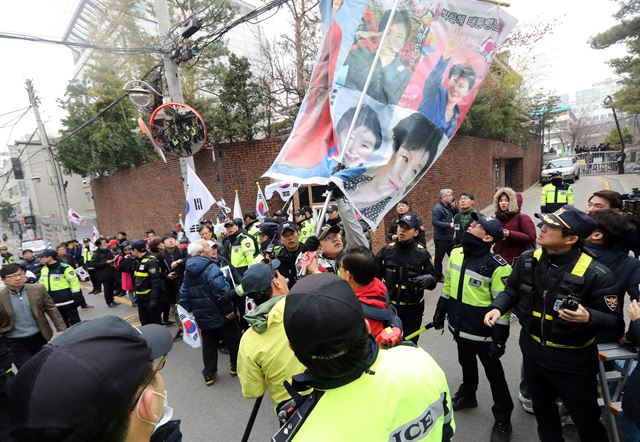 12일 오전 서울 삼성동 박근혜 전 대통령 사저 앞에 탄핵을 반대하는 시민들이 피켓을 들고 있다. 연합뉴스