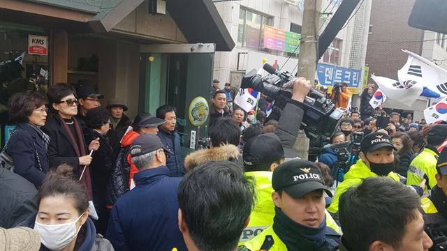 12일 강남구 삼성동 박근혜 전 대통령 사저 앞에서 방송사 카메라를 뺏으려는 지지자들과 취재진 사이에 마찰이 발생했다. 이상무 기자