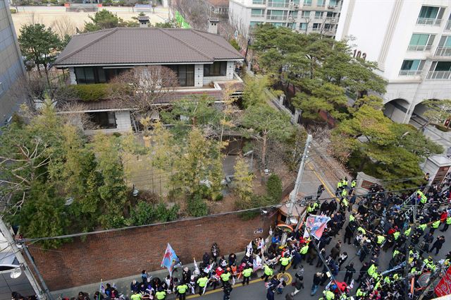 12일 오후 서울 강남구 삼성동 박 전 대통령 자택 앞에 박사모 회원들이 태극기와 성조기를 들고 탄핵 항의시위를 하고 있다. 사진공동취재단