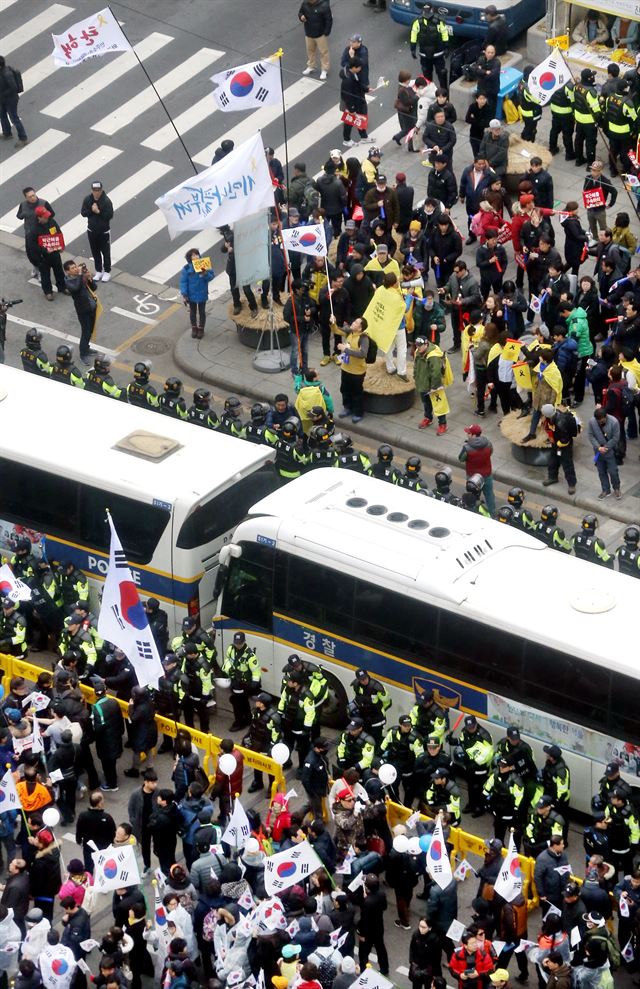 박근혜 전 대통령의 탄핵심판이 진행 중이던 지난 1일, 서울 광화문에서 '대통령 탄핵 기각을 위한 국민총궐기 운동본부'가 주최한 탄핵 반대 집회(아래쪽)와 '박근혜 정권 퇴진 비상 국민행동'이 주최한 탄핵 촛불 집회가 동시에 열려 참석한 시민들이 서로 반대편을 향해 야유를 보내고 있다. 사진공동취재단