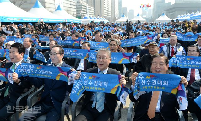 19일 오후 서울 광화문광장에서 송하진(왼쪽 두번째) 전북도지사와 이연택(오른쪽) 대회조직공동위원장 등 참석자들이 함성을 지르며 2017 무주 WTF 세계태권도선수권대회 성공을 기원하고 있다. 홍인기 기자