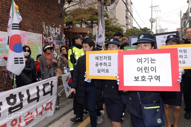 삼릉초등학교 녹색어머니회 학부모들이 20일 오전 어린이보호구역 밖에서 시위해줄 것을 요구하며 피켓을 들고 박근혜 전 대통령 자택 앞을 지나고 있다. 류효진 기자