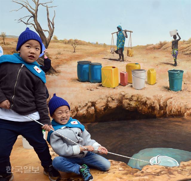 [저작권 한국일보] 20일 서울 종로구 청계천 일민미술관앞에 마련된 가상우물 에서 어린이들이 물 긷기 체험을 하며 힘을 쓰고 있다. 신상순 선임기자그림 2 [저작권 한국일보] 20일 서울 종로구 청계천 일민미술관앞에 마련된 가상우물 에서 어린이들이 물 긷기 체험을 하며 힘을 쓰고 있다. 신상순 선임기자