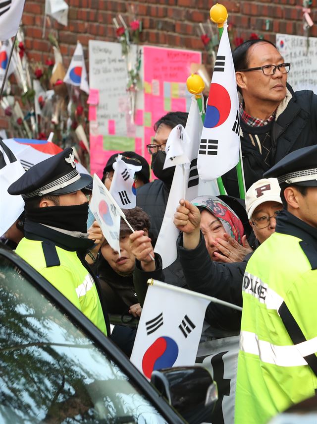 22일 서울 강남구 삼성동 박근혜 전 대통령 자택 앞에서 밤샘 검찰조사를 받고 귀가하는 박 전 대통령을 기다리던 지지자들이 눈물짓고 있다. 연합뉴스