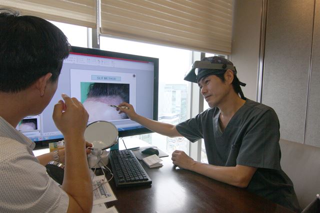 박영도 외과 전문의가 탈모가 진행된 환자에게 모발이식 수술 과정을 설명하고 있다. 대구 모제림외과 제공.