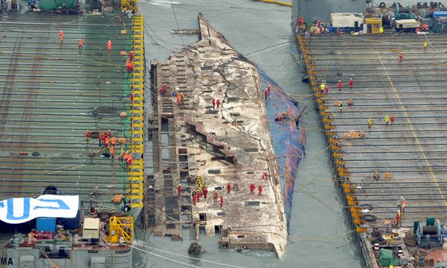 [세5] [저작권 한국일보]23일 오전 세월호 침몰 해역인 전남 진도군 동거차도 앞바다에서 중국 인양업체인 상하이샐비지의 재킹바지선 두척이 세월호 인양작업을 진행하고 있는 가운데 세월호가 모습을 드러내고 있다. 진도=박경우 기자 gwpark@hankookilbo.com /2017-03-23(한국일보)