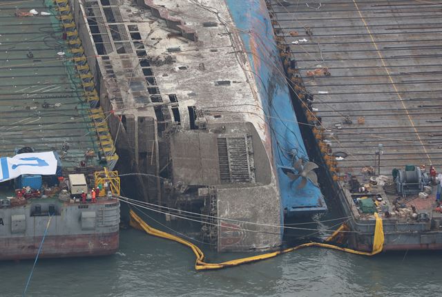 24일 오후 전남 진도군 세월호 사고 해역에서 수면 위 13m까지 올라온 세월호가 2척의 잭킹바지선에 와이어로 묶여 반잠수식 선박으로 이동을 기다리고 있다. 해양수산부는 이날 오후 4시께 3㎞ 떨어진 곳에서 대기 중인 반잠수식 선박으로 본격 이동한다고 밝혔다. 2017.3.24진도=서재훈기자