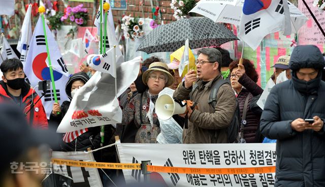 검찰이 박근혜 전 대통령의 구속영장을 청구한 사실이 전해지자, 27일 오후 서울 삼성동 박 전 대통령의 자택 주변에 지지자들이 몰려들어 검찰과 언론을 비난하고 있다. 서재훈 기자 spring@hankookilbo.com