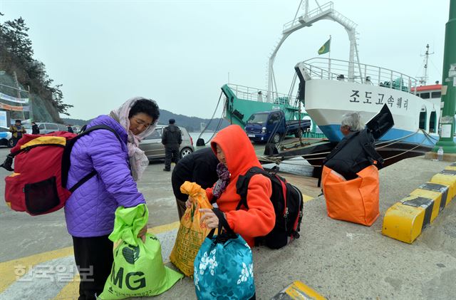 24일 오전 전남 진도 팽목항에서 조도로 향하는 주민들이 철선에 오르기 위해 짐을 챙겨들고 있다. 진도=서재훈기자