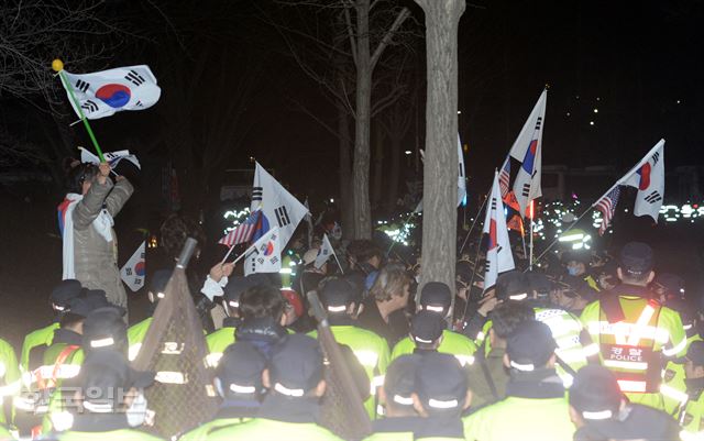 박근혜 전 대통령 지지자들이 31일 새벽 서울구치소에서 태극기를 흔들며 구호를 외치고 있다. 홍인기 기자