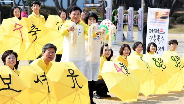 박용갑(왼쪽 세번째) 중구청장이 밀가루 면발을 들고 7~9일 서대전시민공원에서 열리는 '제3회 대전칼국수 축제' 홍보활동을 벌이고 있다. 중구청 제공