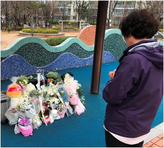 6일 인천 연수구 동춘동 청량어린이공원의 한 벤치에 숨진 8살 여자 초등학생을 추모하는 꽃과 메모지가 가득하다. 한 주민이 숨진 초등학생을 위해 기도하고 있다.