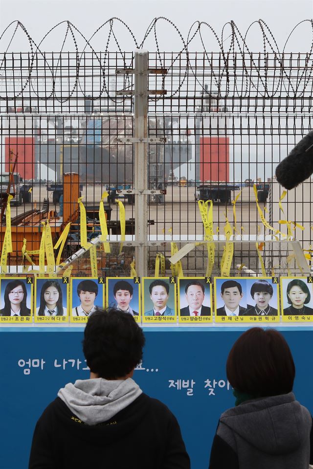 6일 오후 전남 목포 신항 울타리 앞에서 세월호 미수습자 가족들이 반잠수식 선박에 거치된 세월호를 바라보고 있다. 목포=연합뉴스