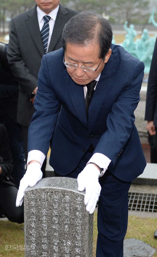 홍준표 자유한국당 대선후보가 6일 광주 국립 5ㆍ18 민주묘지에서 민주화운동 희생자 묘비를 어루만지고 있다. 오대근 기자