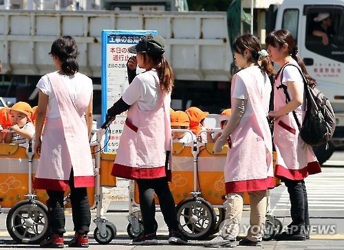 일본의 여성 보육사들이 아이들을 단체로 이동시키고 있다. 연합뉴스 자료사진