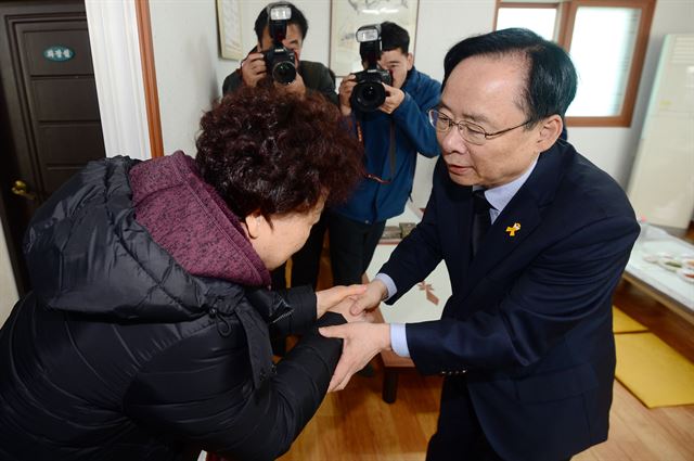 이주영 전 해양수산부 장관이 지난달 26일 오후 전남 진도군 임회면 팽목식당에서 세월호 참사 미수습자 가족들의 손을 잡고 있다. 뉴스1