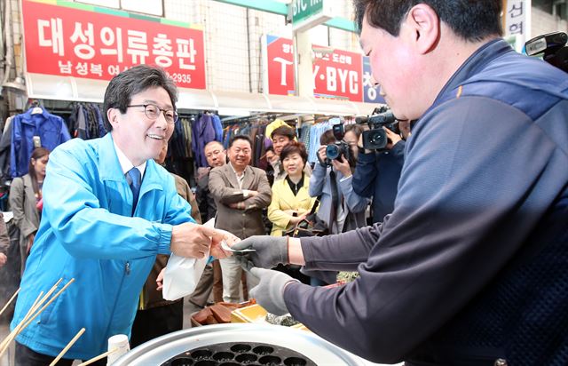 유승민 바른정당 대선 후보가 10일 오전 청주시 육거리시장을 찾아 음식을 사고 있다. 청주=연합뉴스