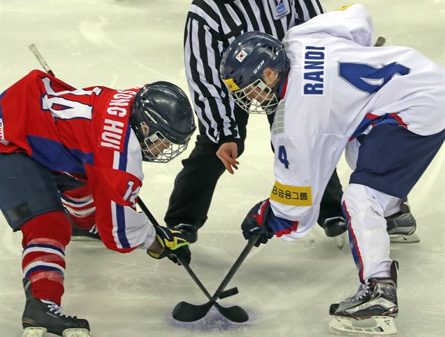 지난 6일 한국과 북한의 맞대결로 열렸던 ‘2017 IIHF 여자 세계선수권 대회’에서 그리핀 란디 한국 선수와 려성희 북한 선수가 퍽을 다투고 있다. 연합뉴스