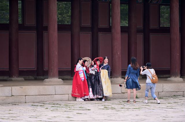 지난해 5월 관광객들이 25일 서울 경복궁에서 한복을 입은 내외국인 관광객들을 휴대폰 카메라에 담고 있다. 코리아타임스 자료사진