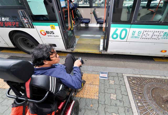 집을 나선 지 30분만에 도착한 버스 정류장에서 또다시 25분을 기다린 끝에 도착한 저상버스. 그러나 휠체어를 위한 슬라이드 안전발판이 고장 나 있었다. 황씨가 실망스런 표정을 짓고 있다.