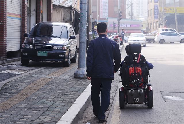 신도림역으로 향하던 황씨가 갑자기 보도를 벗어나 차도를 달리고 있다. 불법 주차된 차량을 비롯해 전봇대나 화분 등 보도를 점령한 모든 구조물이 전동휠체어의 통행을 방해하는 요소다.