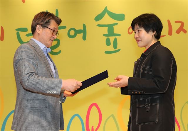 유종필(왼쪽) 관악구청장이 19일 구청 대강당에서 김성자씨에게 독서홍보대사 위촉장을 전달하고 있다. 관악구 제공