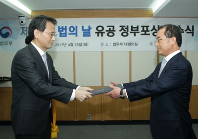 이창재 법무부 장관 직무대행(사진 왼쪽)이 25일 경기도 정부과천청사 법무부 대회의실에서 제54회 '법의 날' 유공 정부포상 전수식에서 강용현 태평양 고문 변호사에게 국민훈장 무궁화장을 전수하고 있다. 법무부 제공