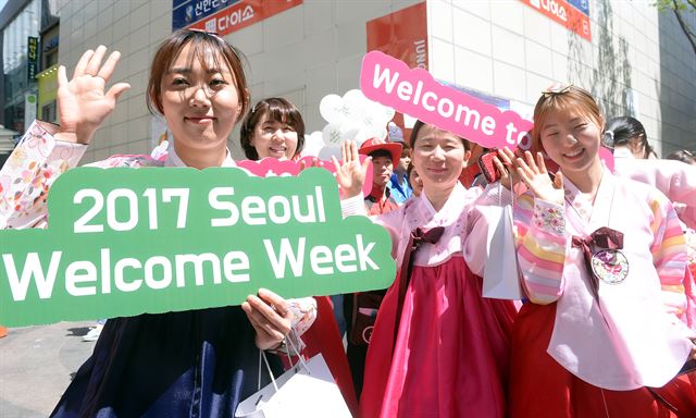 27일 오전 서울 명동에서 열린 관광객 환대주간 개막식에서 한국방문위원회, 대학생 환대 서포터즈 등 참석자들이 한복을 입고 환대주간을 알리는 홍보를 하고 있다.배우한 기자