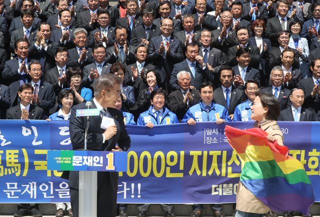 26일 서울 여의도 국회 본청 앞에서 열린 국방안보 분야 1,000인인 지지선언에 참석한 문재인 더불어민주당 대선 후보에게 동성애를 상징하는 무지개 깃발을 든 시위자가 접근하고 있다. 연합뉴스