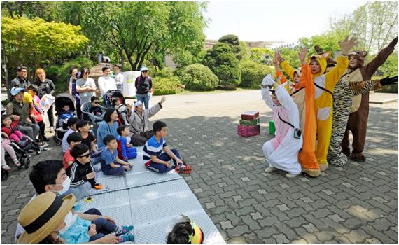 지난해 5월 어린이대공원에서 열린 동화축제를 찾은 가족 단위 방문객들이 동화구연을 감상하고 있다. 광진구 제공