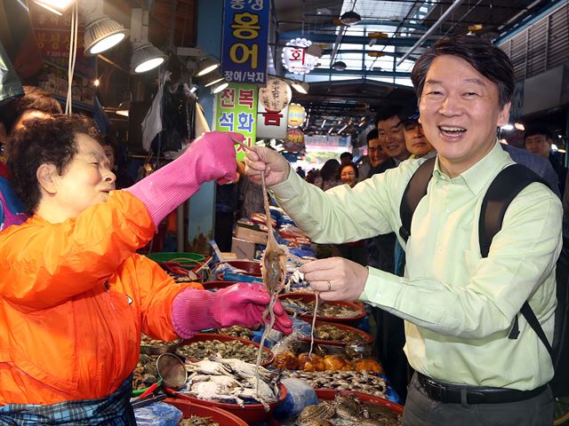 도보유세를 펼치는 안철수 국민의당 대선 후보가 6일 오전 광주 남광주시장에서 상인들과 대화를 나누며 낙지를 살펴보고 있다. 국민의당 제공